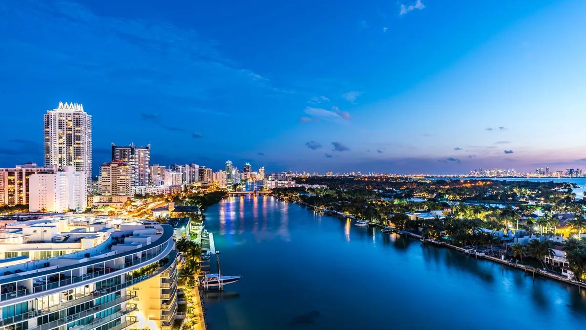 Aerial view of Miami's waterfront at dusk — the real city behind Vice City's layout.